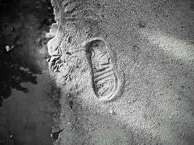 人脚在水泥地面上的灰度照片